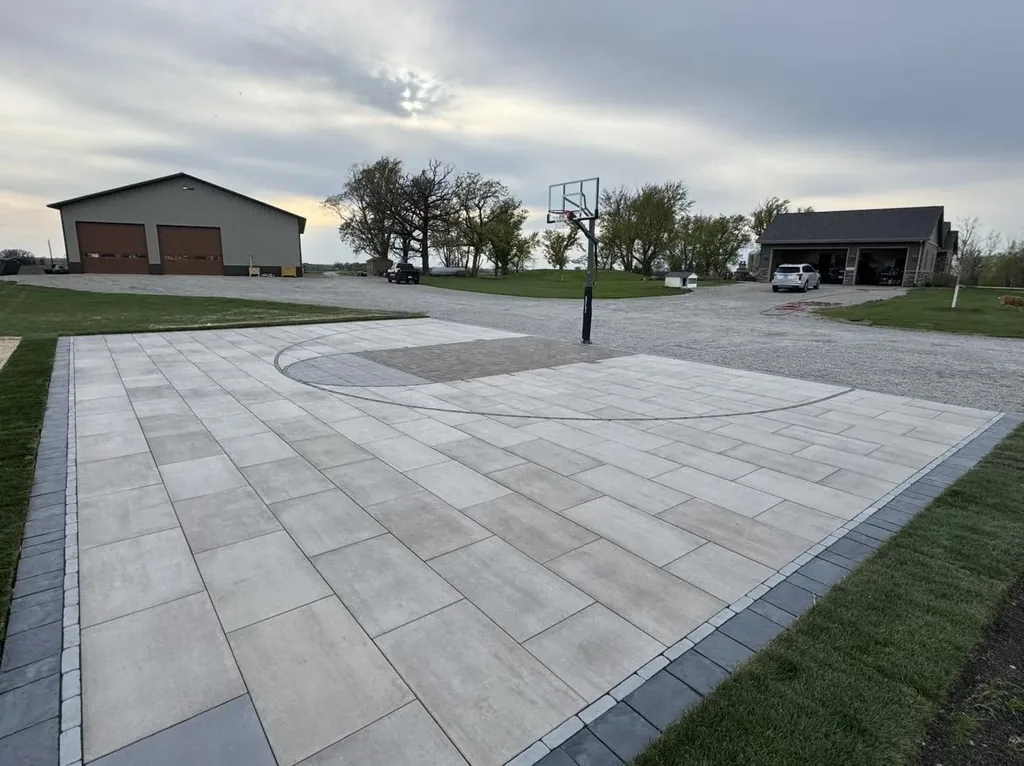 Completed light-gray paver driveway with a dark border