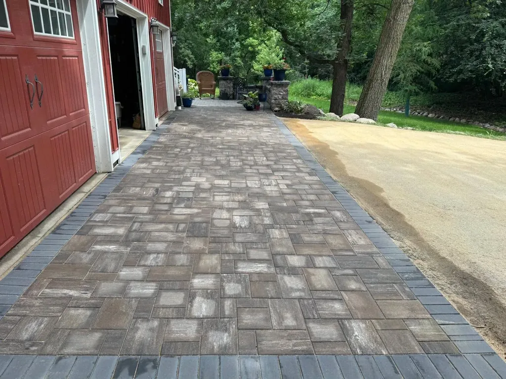 Paver driveway beside a red garage